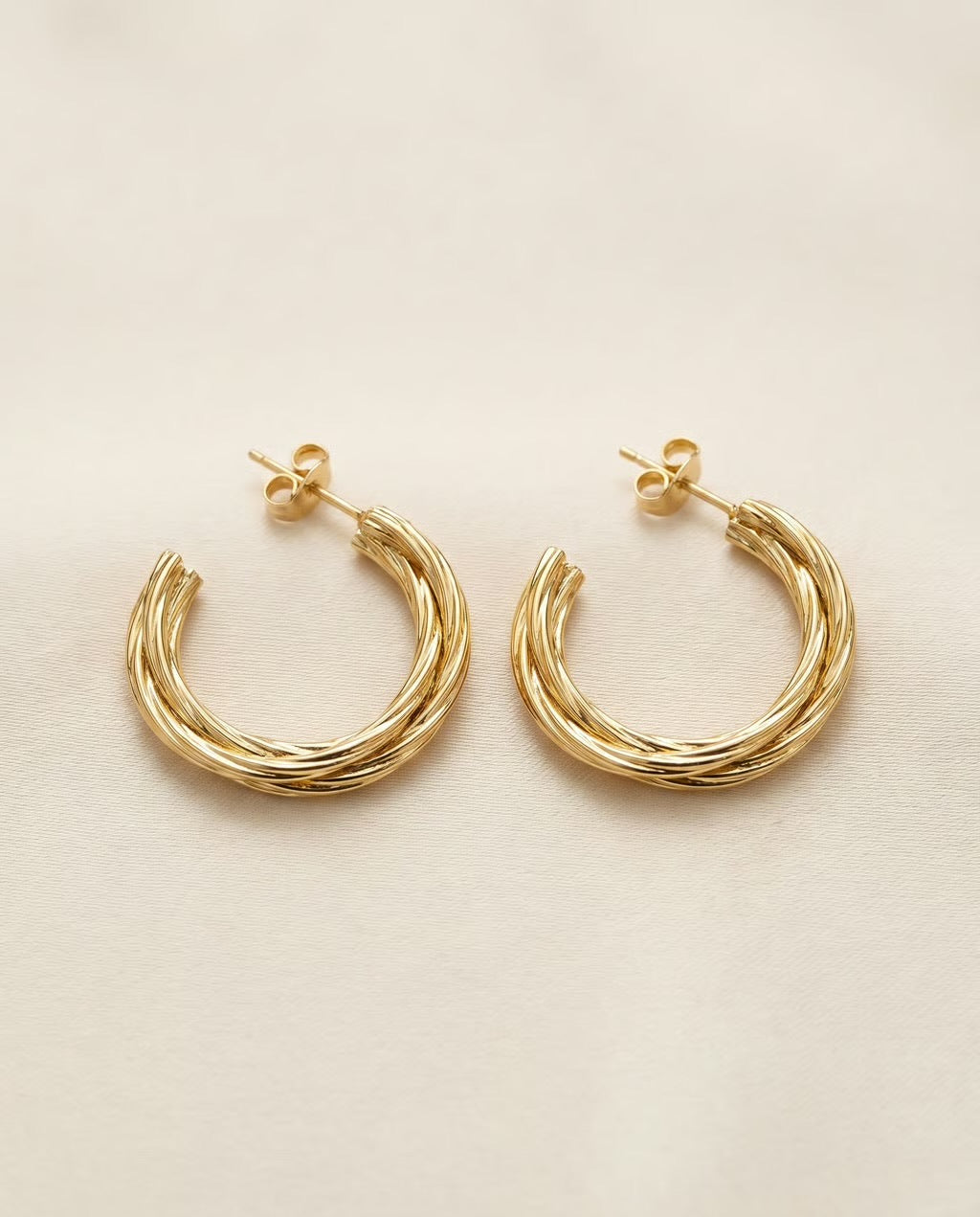 gouden twisted hoops oorbellen met subtiele structuur close up