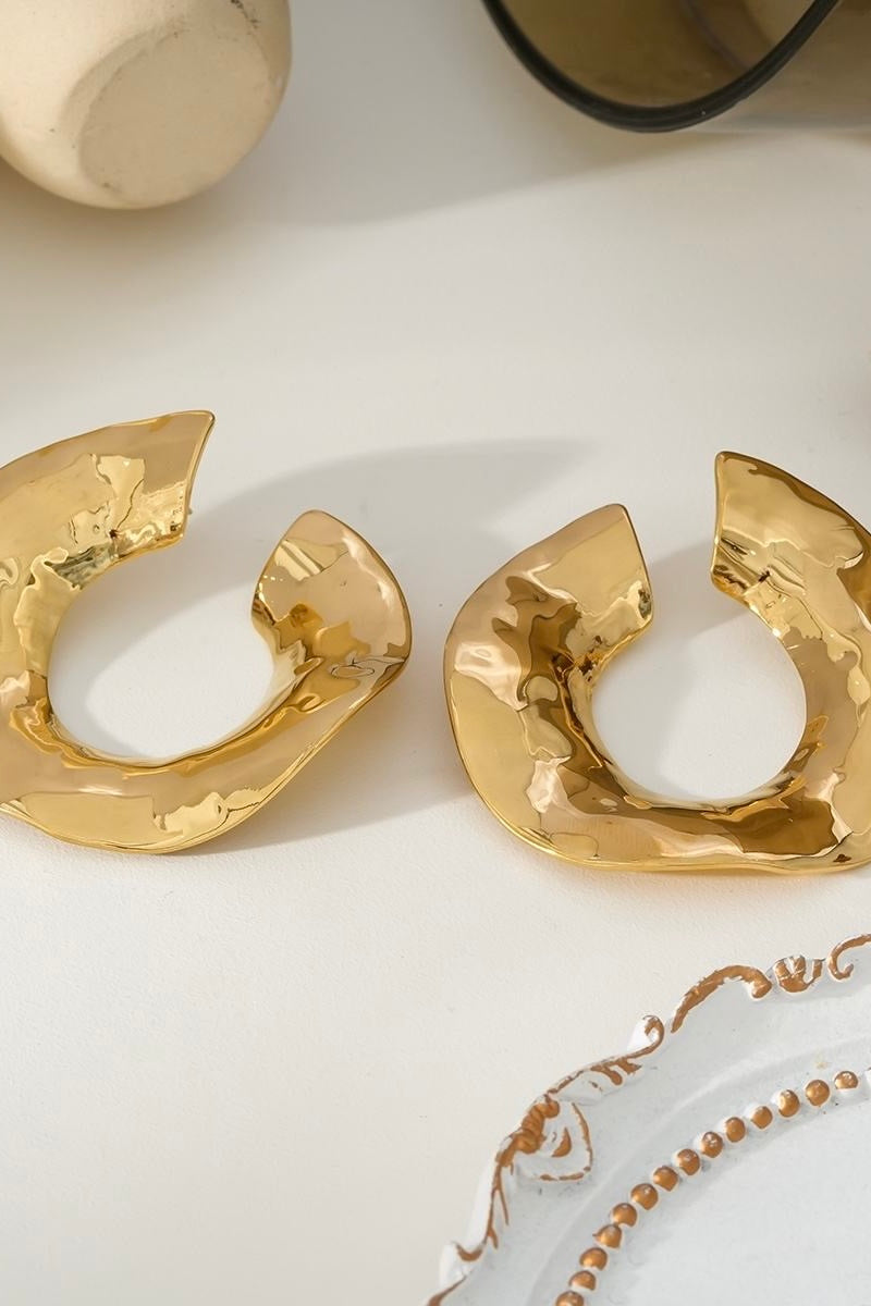 Detail van organische oorringen goud met structuur