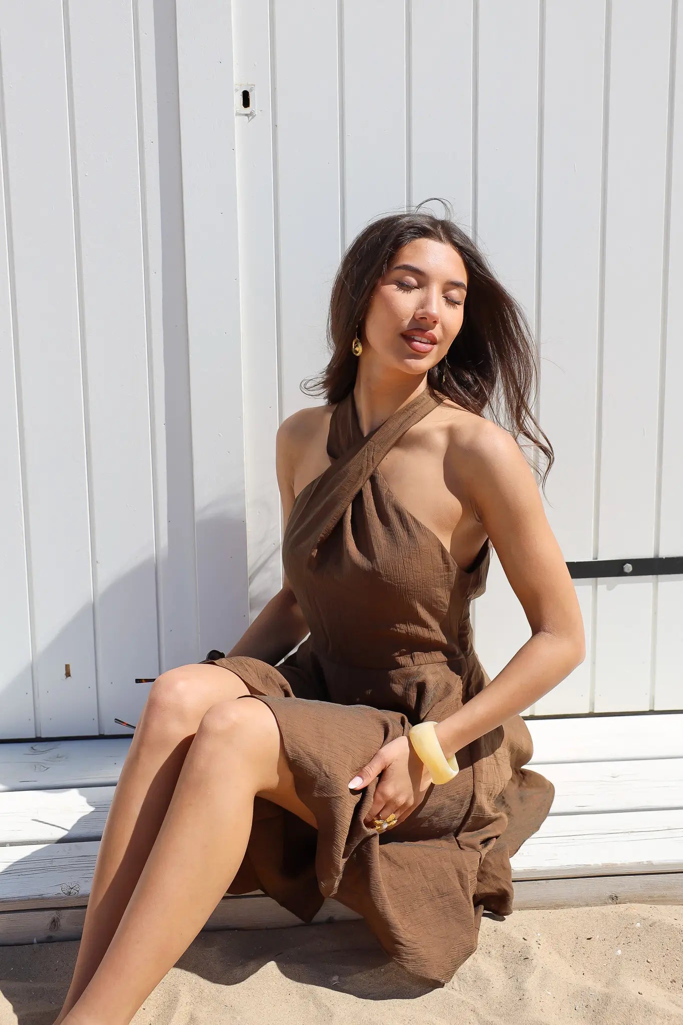 Model zit met overslag jurk bruin