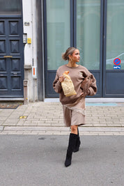 Paris Club Sweater in beige lopend voor blauwe deur