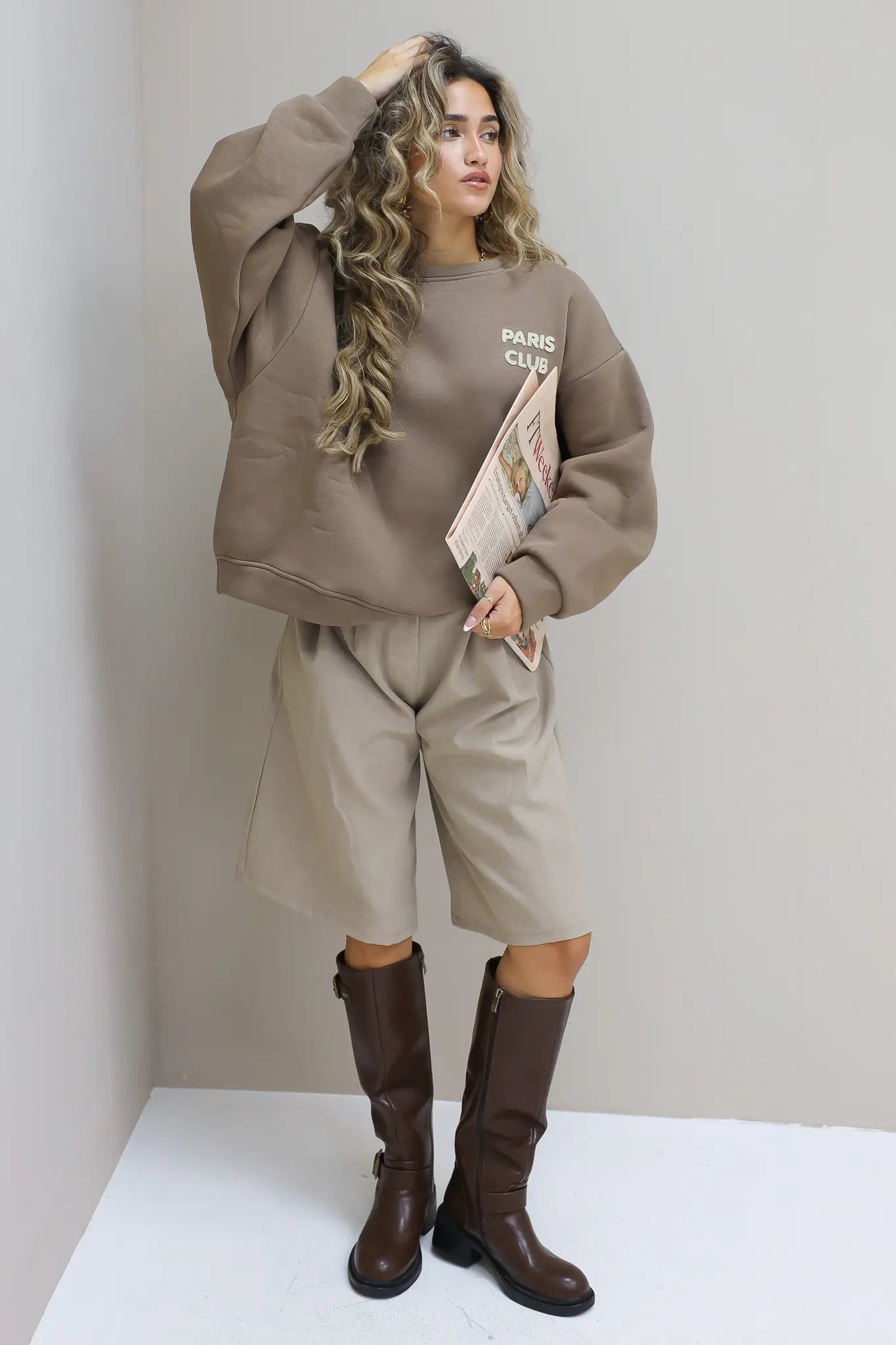 Paris Club Sweater in beige met knielaarzen voor de muur