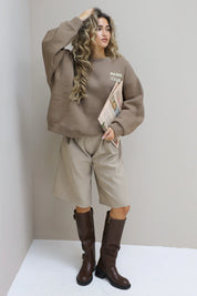 Paris Club Sweater in beige met knielaarzen voor de muur