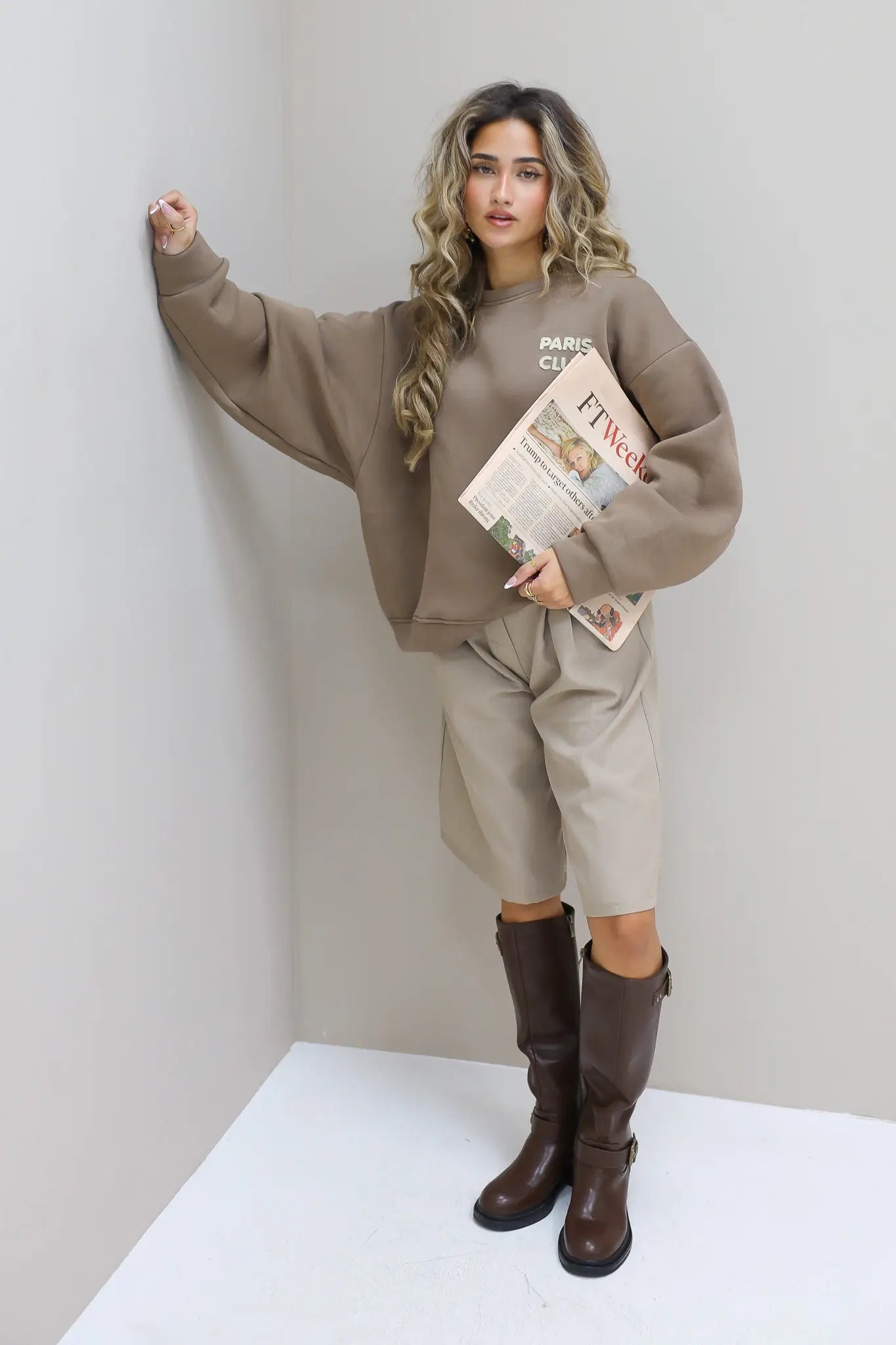 Paris Club Sweater in beige met laarzen poserend