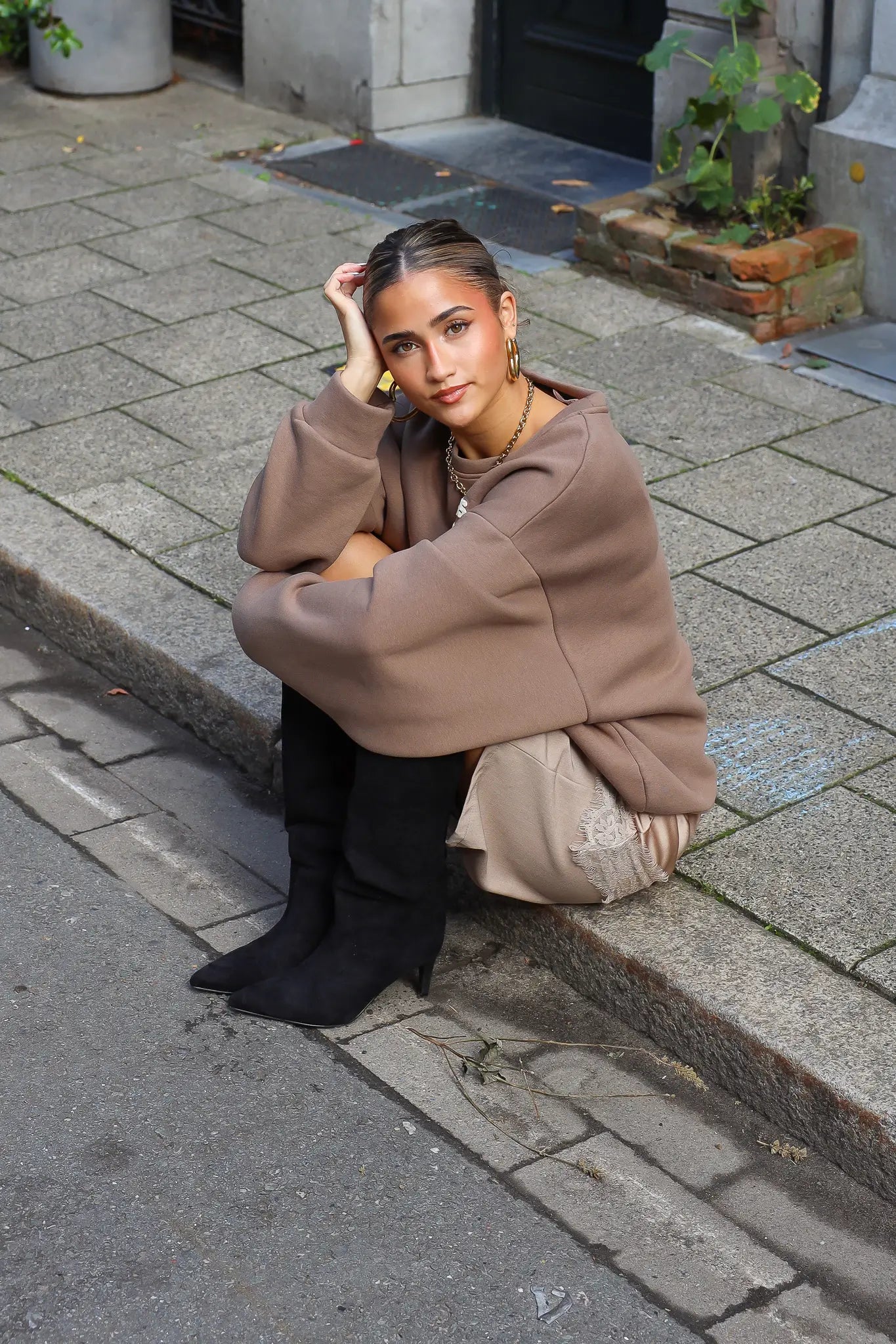 Paris Club Sweater in beige zittend op straat met tas