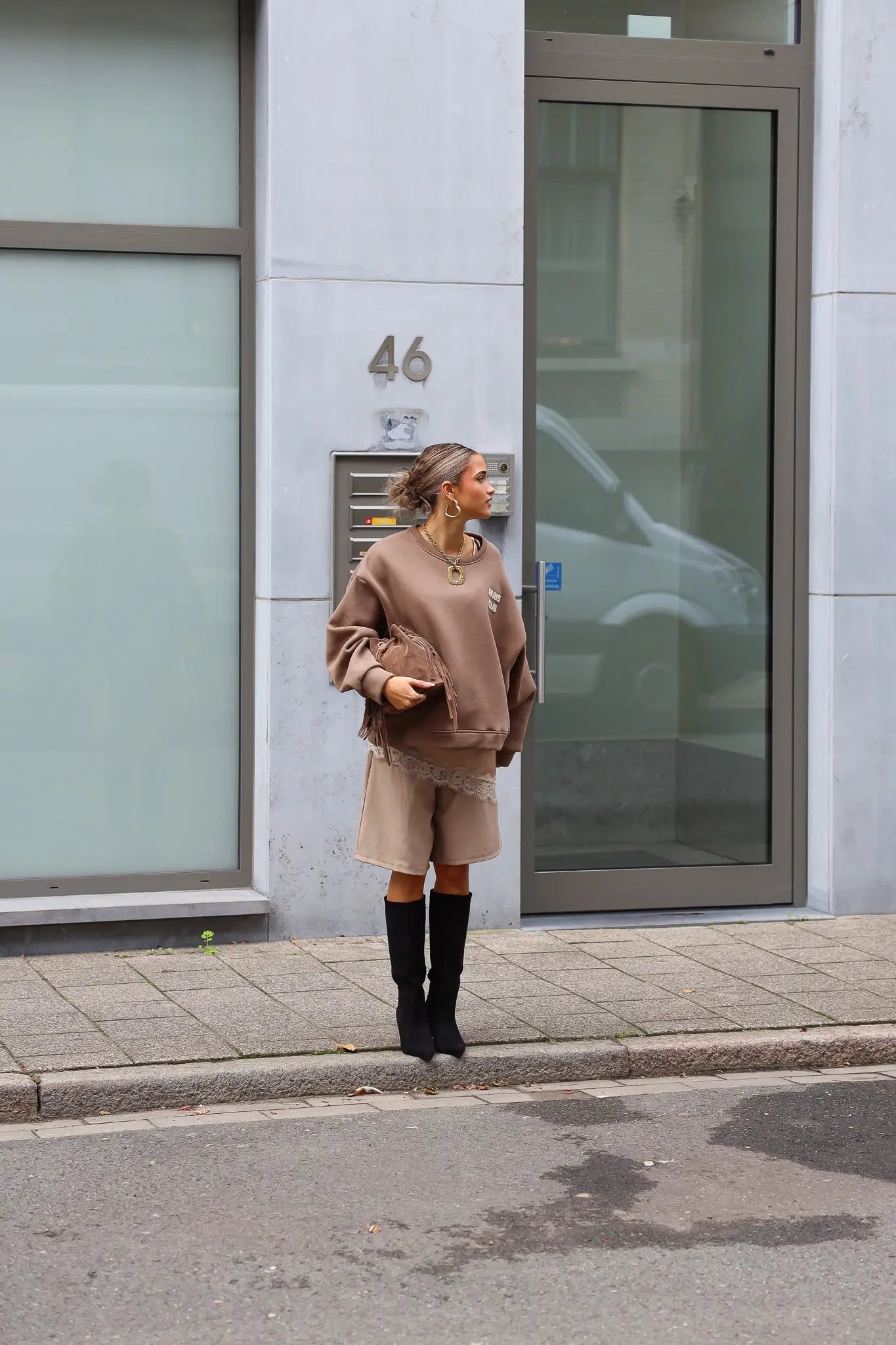 Paris Club Sweater in beige voor een gebouw gefotografeerd