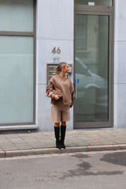 Paris Club Sweater in beige voor een gebouw gefotografeerd