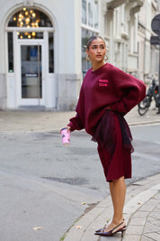 Paris Club Sweater in bordeaux gefotografeerd op straat bij gebouwen