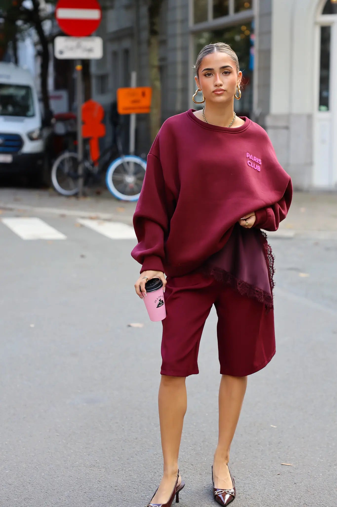 Paris Club Sweater in bordeaux staand buiten op de stoep