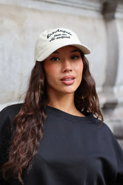 Beige Los Angeles pet met zwarte geborduurde tekst en gebogen klep gedragen met zwarte sweater