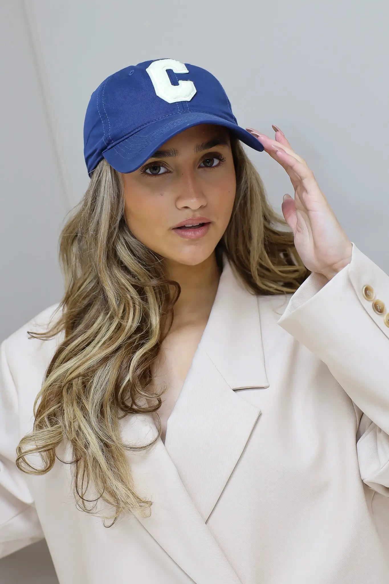 model draagt blauwe pet dames studio look