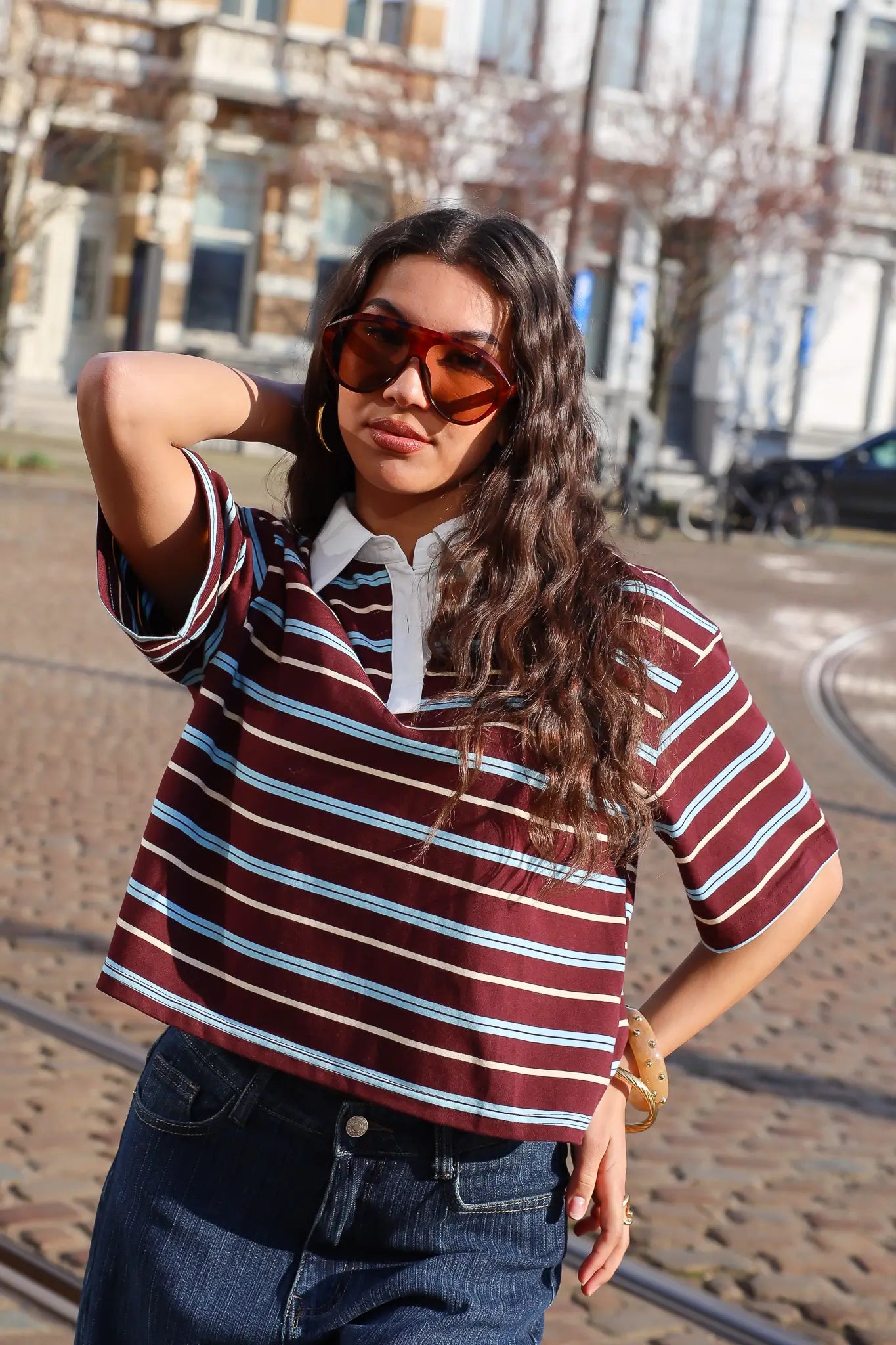 model draagt bruin gestreept polo t shirt korte mouwen met jeans