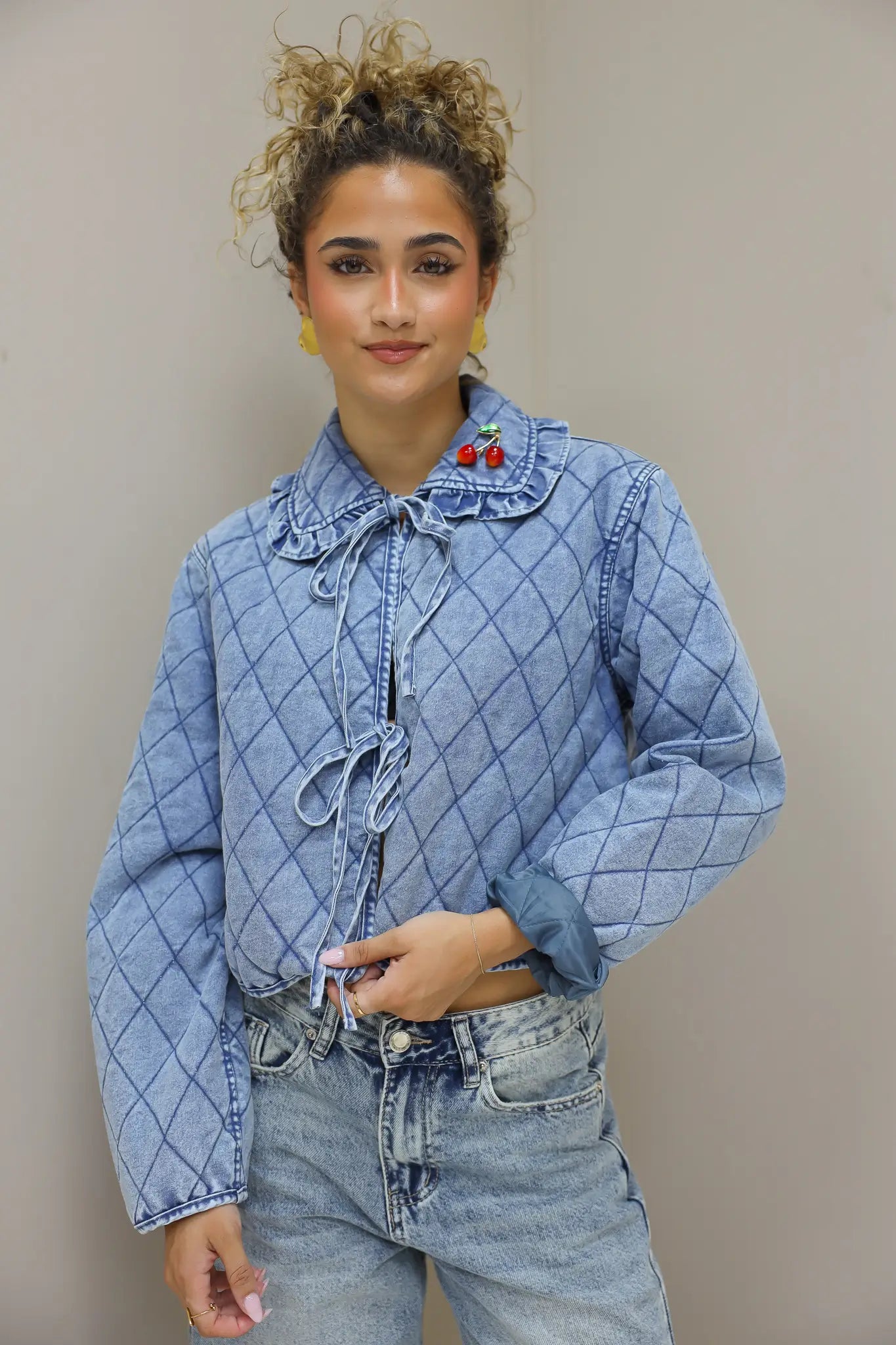 model houdt de knopen van het blauw quilted jasje vast