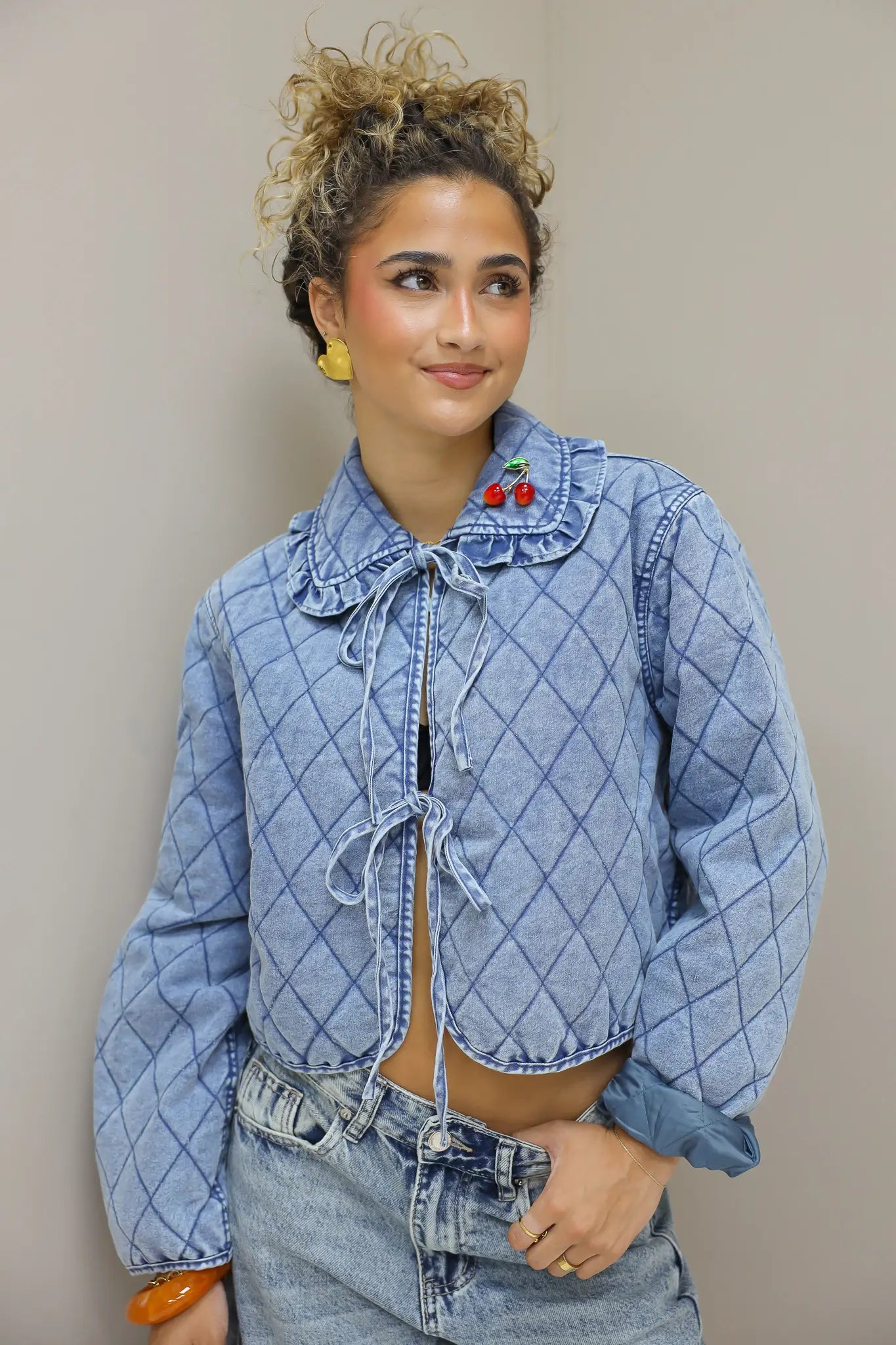 model draait licht zijwaarts met blauw quilted jasje