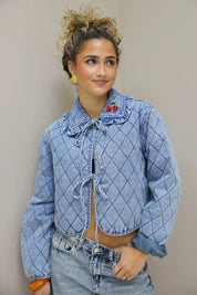 model draait licht zijwaarts met blauw quilted jasje