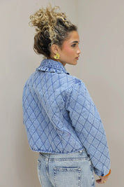 model in studio zijaanzicht met blauw quilted jasje