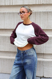 Crèmekleurige dames longsleeve met chocoladebruine raglanmouwen gecombineerd met blauwe wide leg jeans
