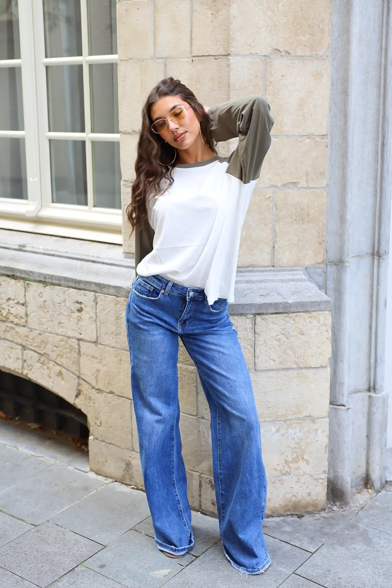 Extra lange wide leg jeans in blauwe denim met wijde pijpen gedragen met een witte top en groen vest