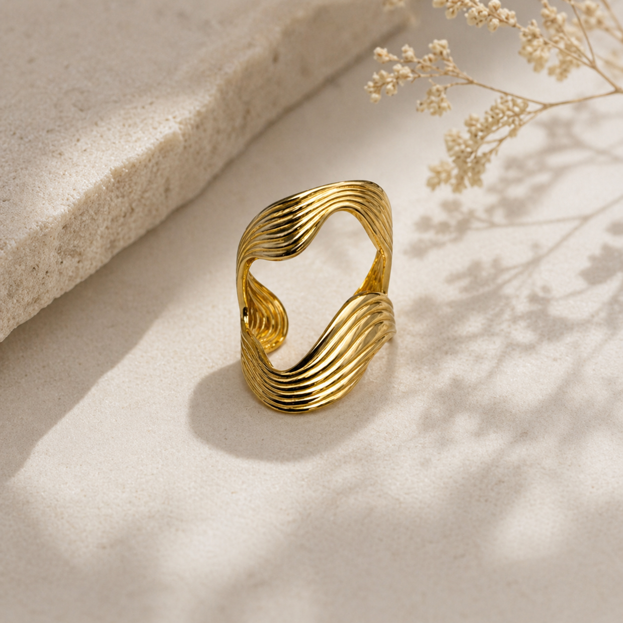 gouden flowy ring met golvend design close up