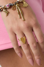 Hand met gouden hart ring gecombineerd met armbanden
