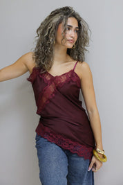 model met rode top, jeans en gouden armband