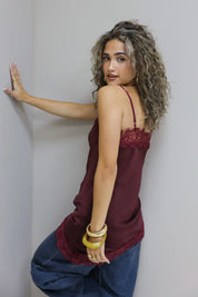 model met rode satijnen top met kanten afwerking en open rug