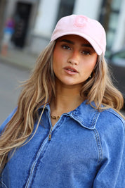 model draagt roze pet dames street style look