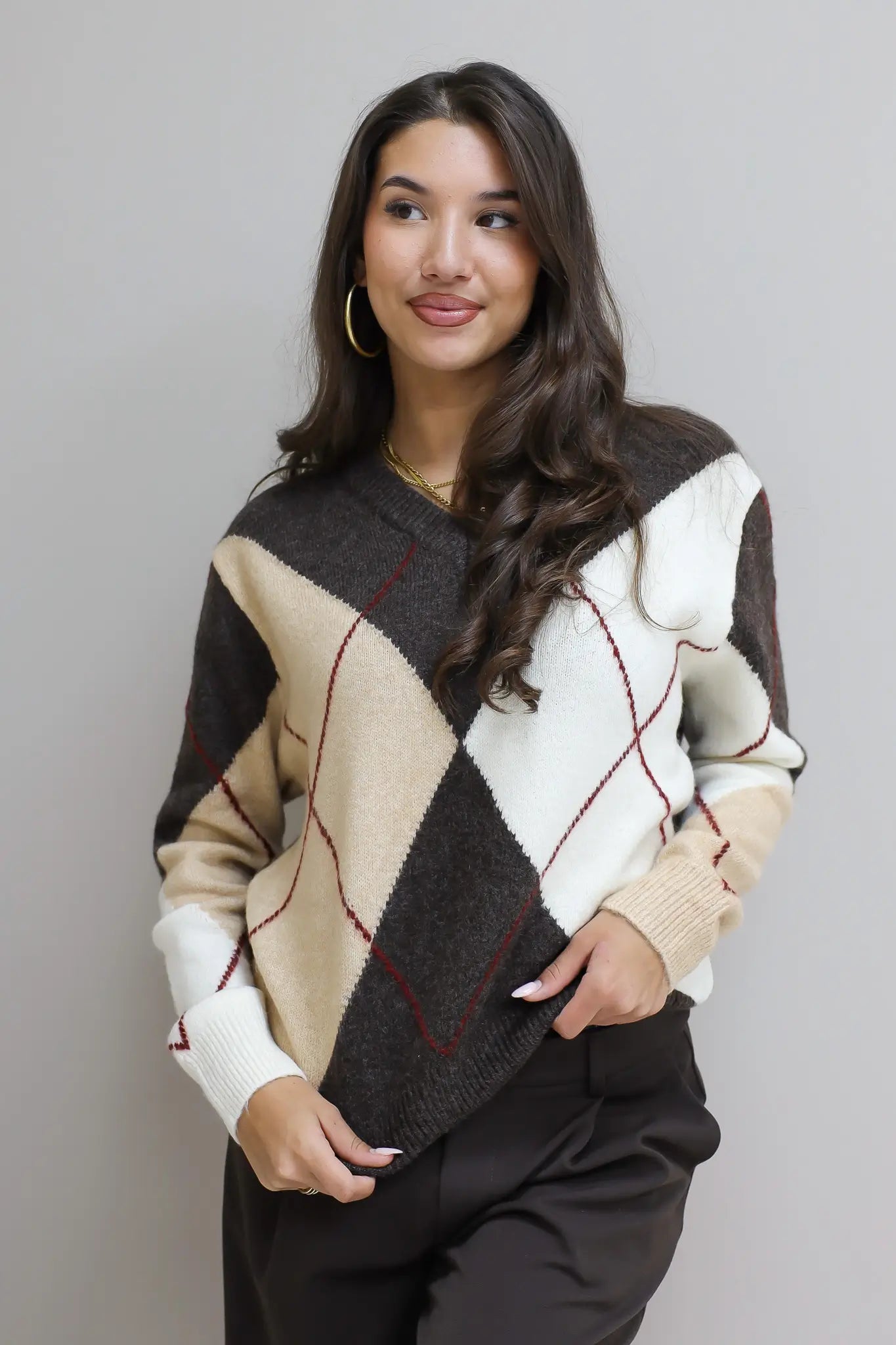 model draagt beige bruine ruit trui met lange mouwen
