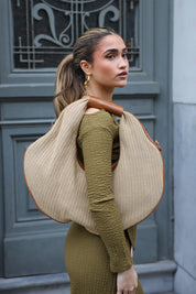 Shopper van raffia en leer bruin gedragen over de schouder