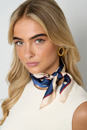 Model draagt sjaal polka dots blauw om de hals, gecombineerd met witte top