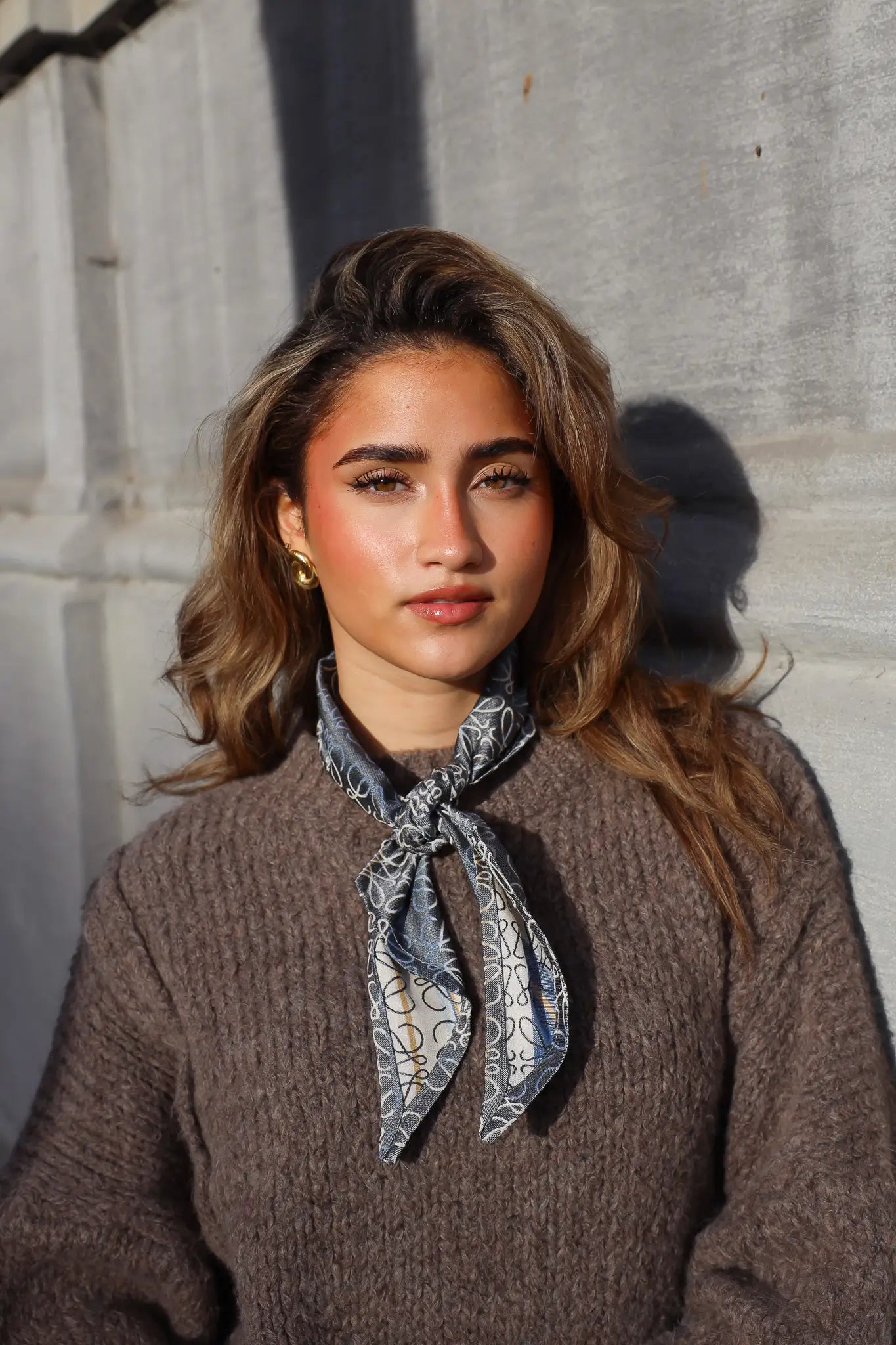 Handgemaakte grijze sjaal met print geknoopt om de hals