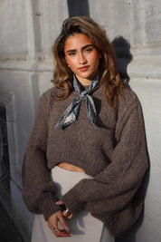 Handgemaakte sjaal met grijze print gedragen bij trui