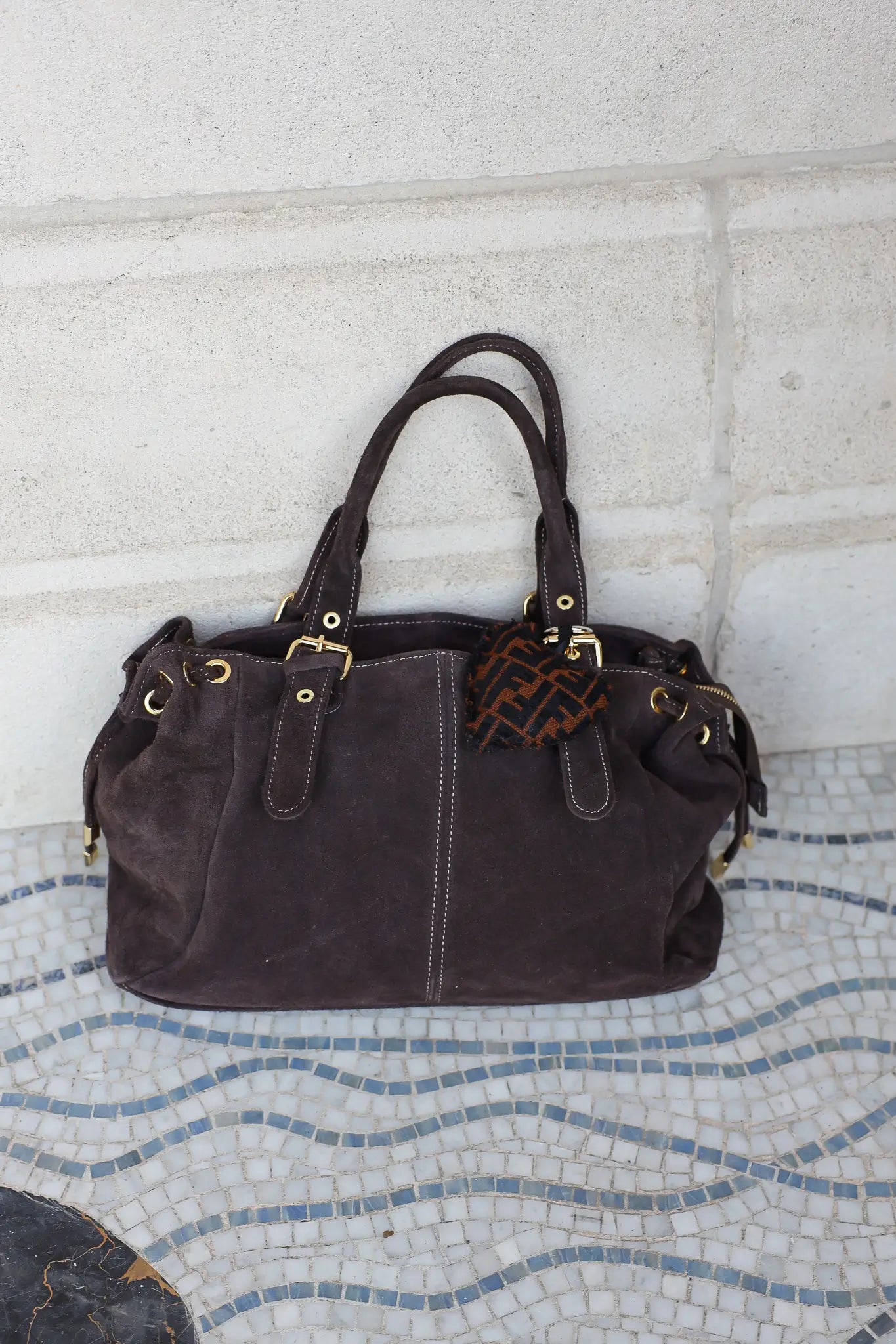 Bruine sleutelhanger met hartjesprint bevestigd aan tas