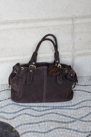 Bruine sleutelhanger met hartjesprint bevestigd aan tas