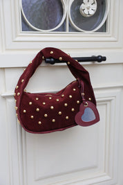 Bordeaux hartvormige sleutelhanger hangt aan bordeaux handtas