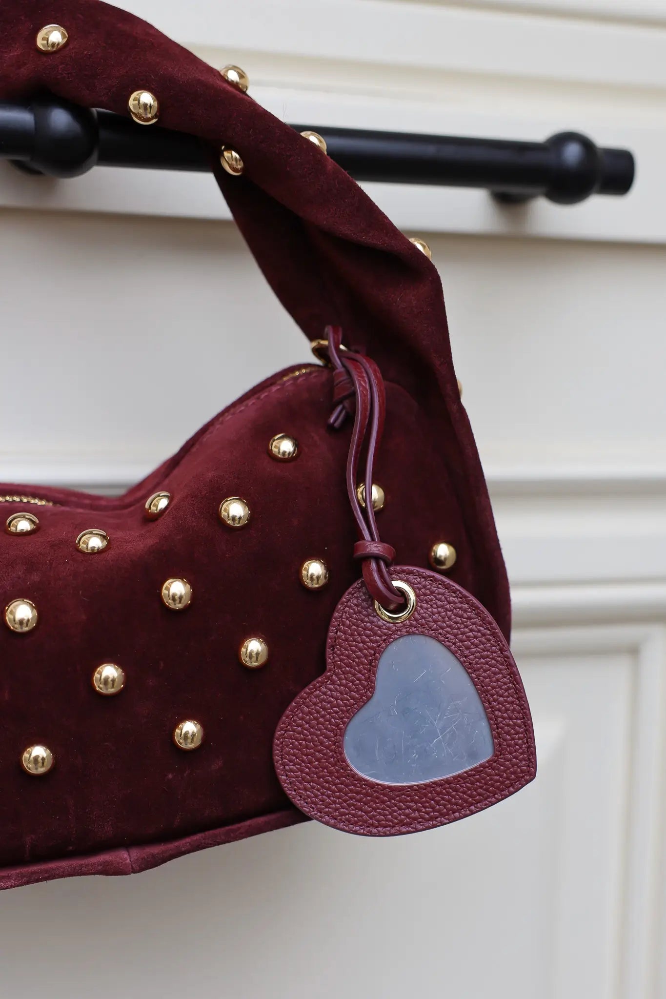 Bordeaux sleutelhanger met hartvormige spiegel aan tas met studs
