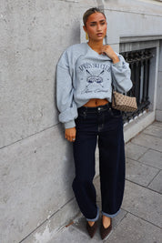 Lichtgrijze Après Ski Club sweater gestyled met wide leg jeans en een schoudertas