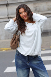 Lichtgrijze dames sweater met studs gecombineerd met casual jeans