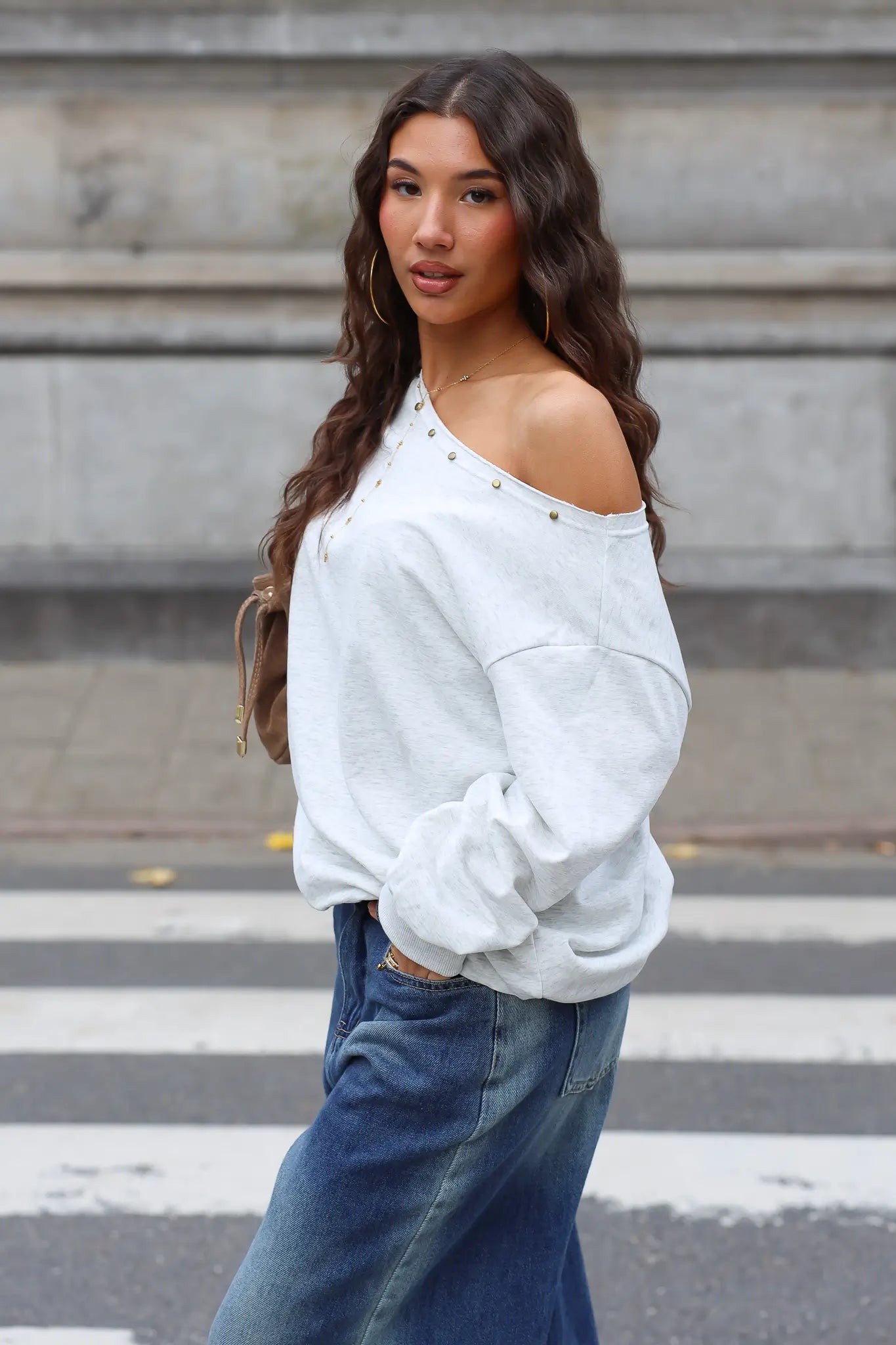 Off shoulder sweater lichtgrijs gecombineerd met blauwe wijde spijkerbroek