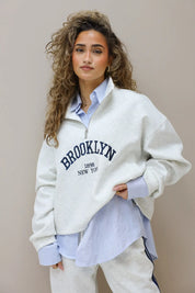 detail van de brooklyn opdruk op grijze sweater