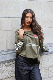 Khaki dames shirt met wijde hals en lange mouwen gecombineerd met zwarte jeans