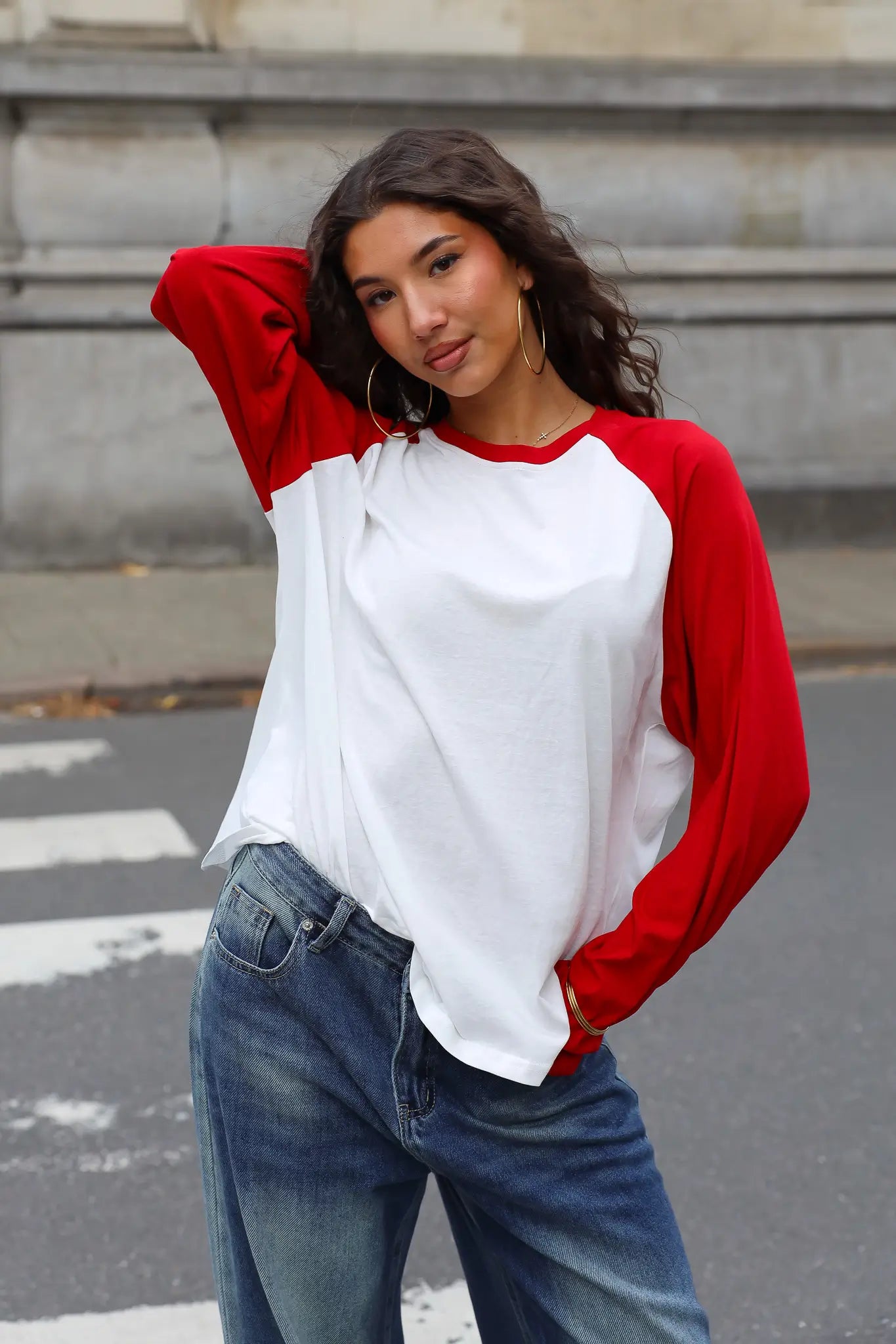 Raglan shirt met witte voorkant en rode mouwen gedragen met blauwe jeans