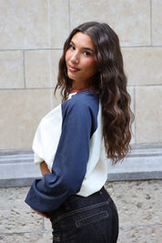 Achter- en zijaanzicht van het crème Adventure longsleeve T-shirt met donkerblauwe mouwen, gedragen op een donkere jeans.