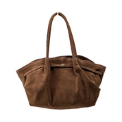 taupe suède shopper met dubbele hengsels gefotografeerd op witte achtergrond