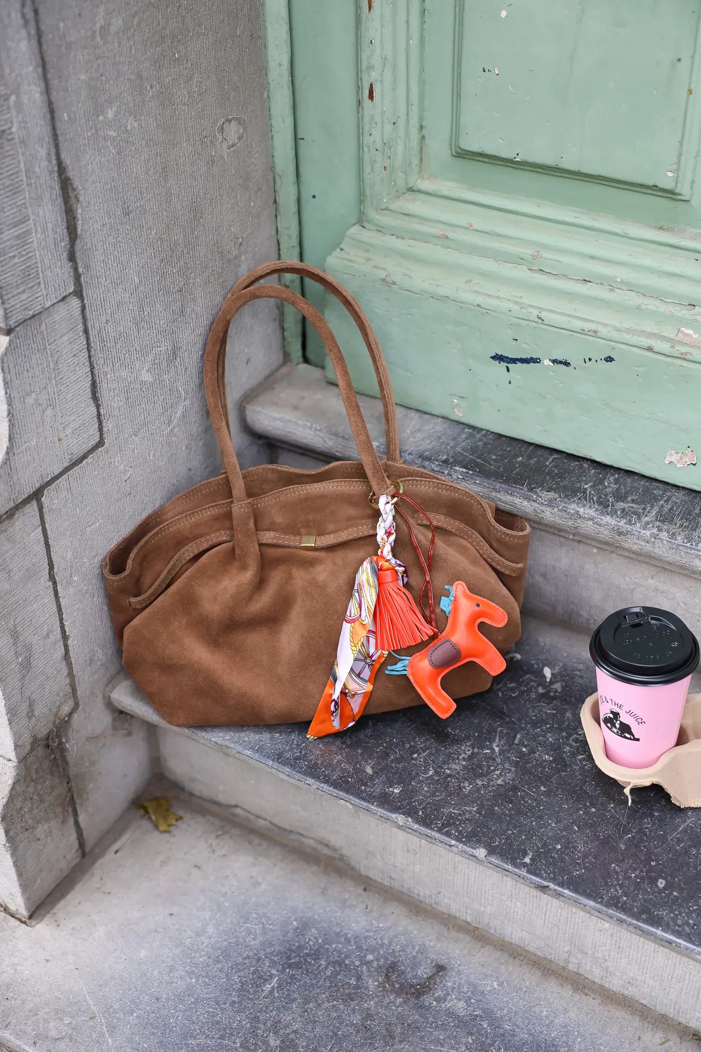 taupekleurige suède shopper met dubbele hengsels op witte achtergrond