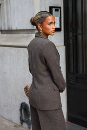 Getailleerde taupe blazer met reverskraag en dubbele rij knopen gedragen met een bijpassende pantalon