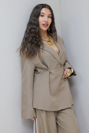 Model in taupe oversized blazer met pantalon vanaf de zijkant gefotografeerd