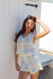model staat met hand in haar met gehaakte top beige blauw