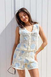 model ligt zijwaarts op zonnebed met gehaakte top beige blauw