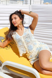 model met zonnebril in hand draagt gehaakte top beige blauw