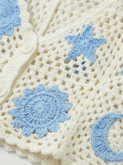 detail van gehaakt patroon in beige en blauw top